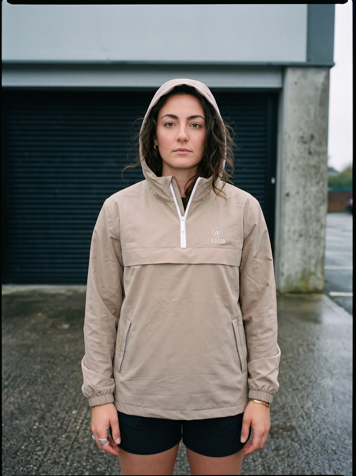 AP Club Shell Jacket in black at a wet outdoor padel court