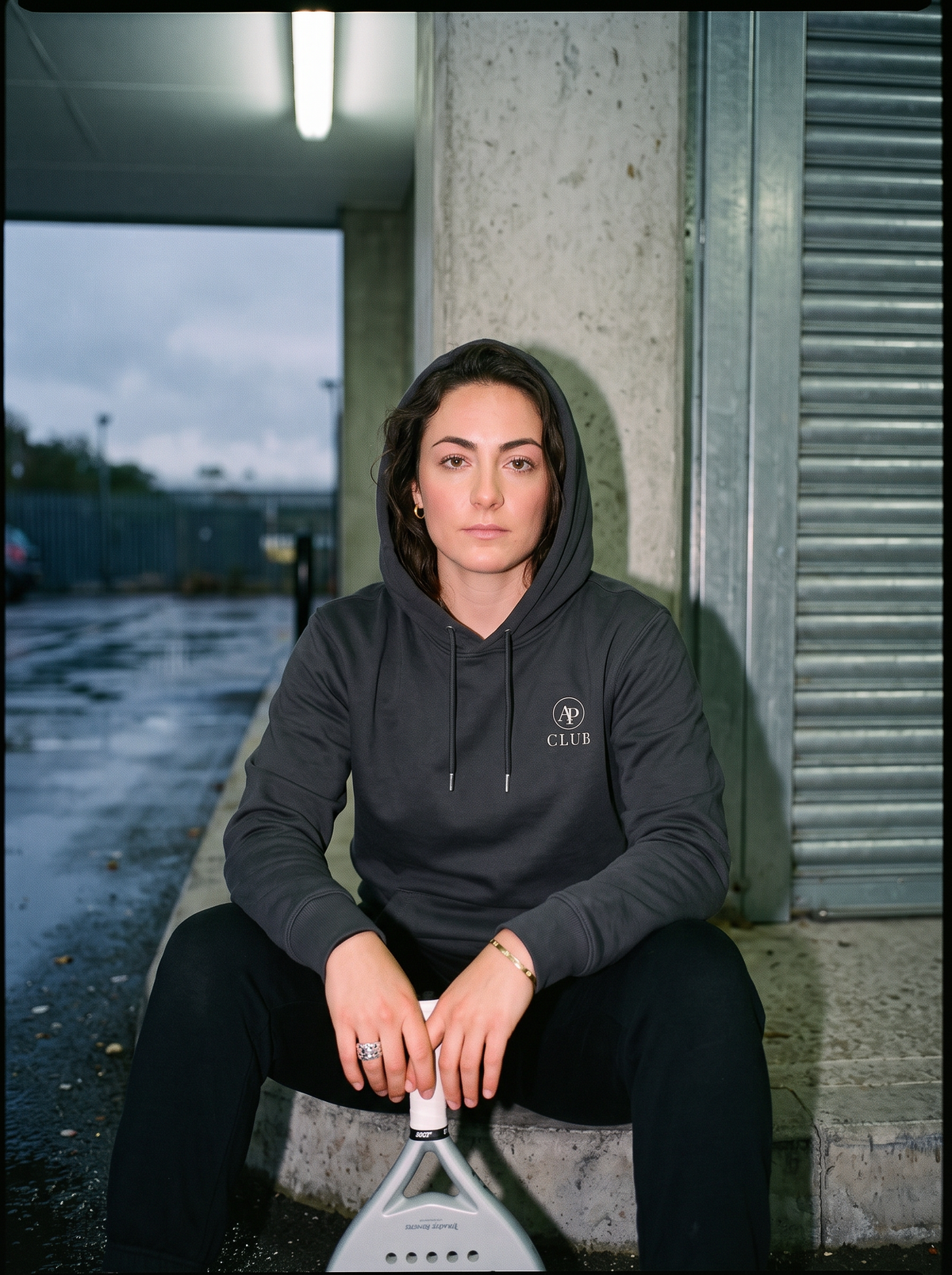 AP Club Vamos heavyweight black padel hoodie at an indoor court