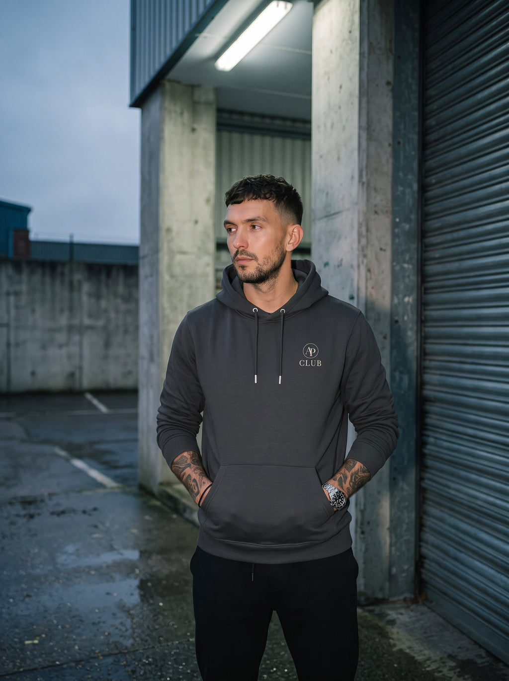 AP Club Vamos heavyweight padel hoodie photographed outside the court