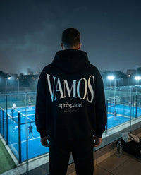 Person wearing AP Club VAMOS hoodie on a padel court at night.