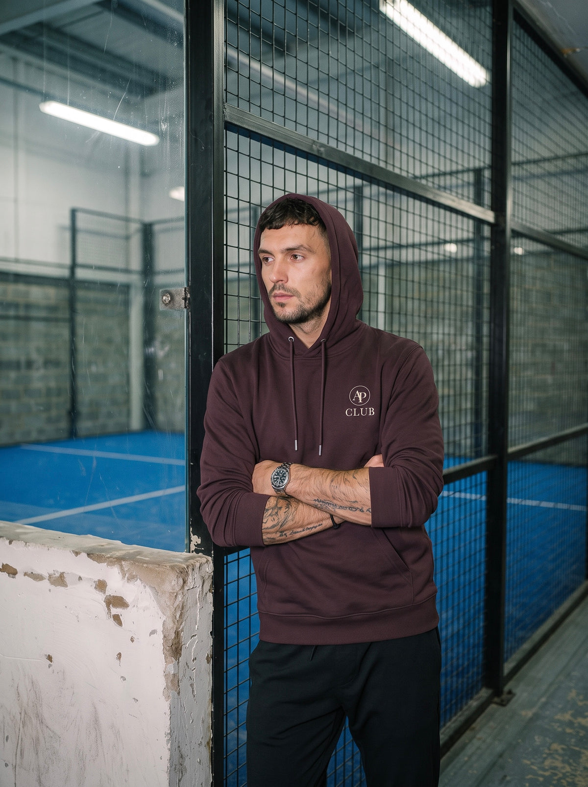 AP Club Por Tres heavyweight Red Brown padel hoodie beside the court