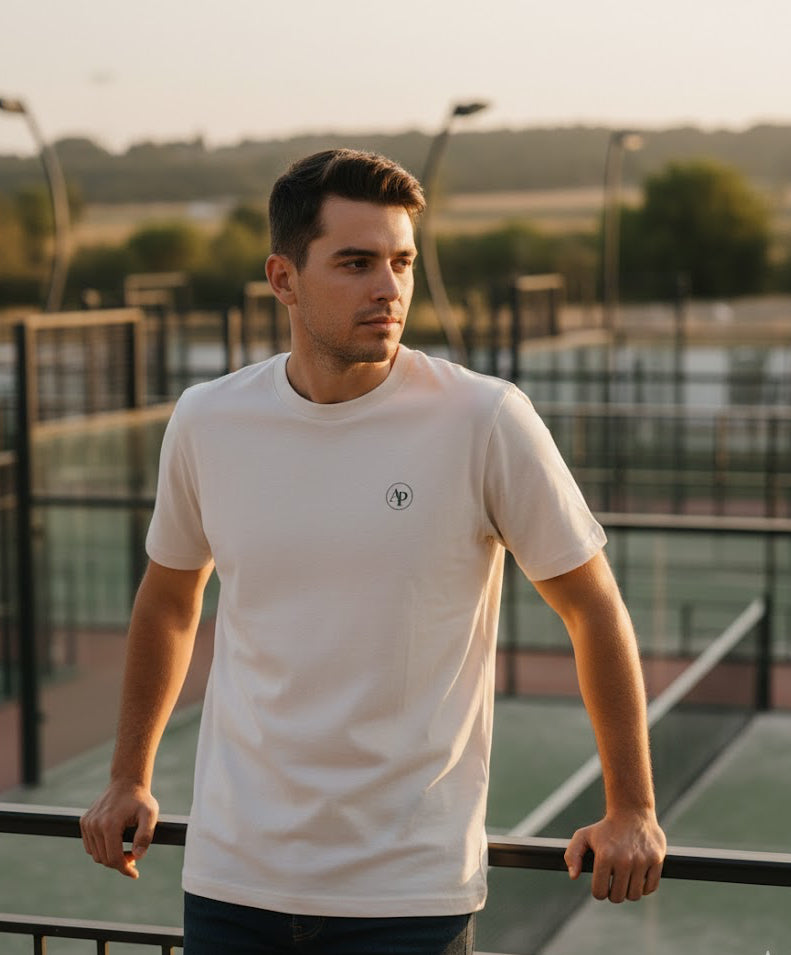 Man wearing a white AP Club t-shirt with a logo on a sports court