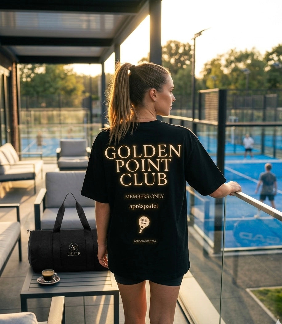 Female wearing a black AP Club 'Golden Point Club' t-shirt on a padel court.